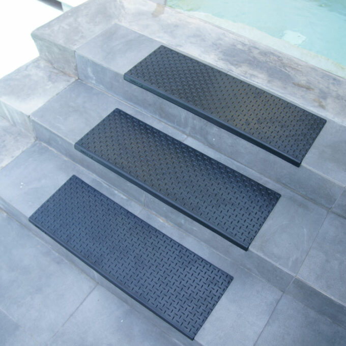 Non-Skid, Affordable, Sturdy and Eco-Friendly Step Mats black in color placed on staircase near swimming pool