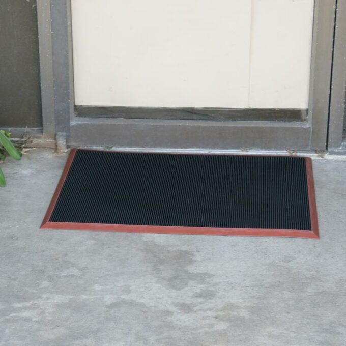 Doormat with red border placed in front of door