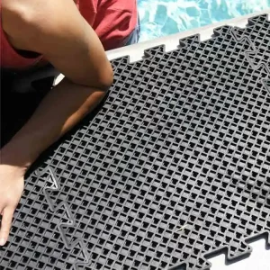 Black eco drain tile next to a swimming pool and someones elbow on it