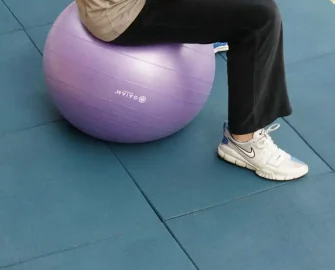 A person doing ball exercise on blue color Ultra Durable, DIY Rubber Tiles