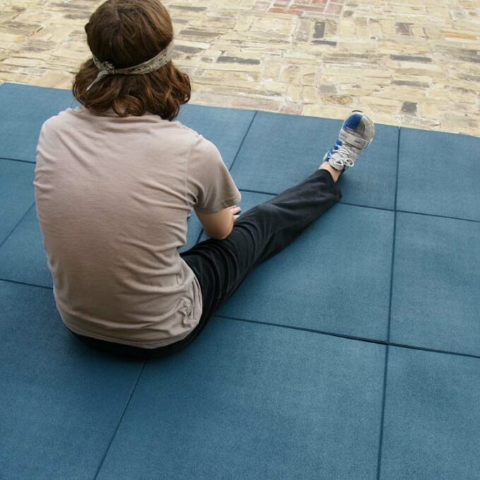 Man is sitting on blue color Ultra Durable, DIY Rubber Tiles