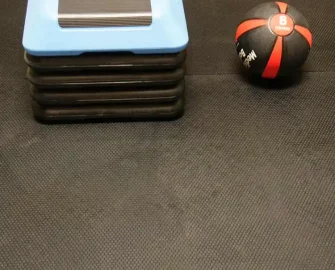 shot of black circle pattern matt with a ball and a case next to it