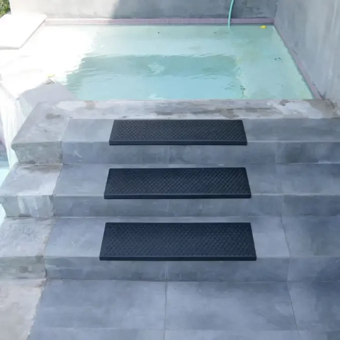 Black color Do It Yourself Installation, Non-Slip, Ultra Durable, Indoor/Outdoor Stair Treads placed on staircase near swimming pool