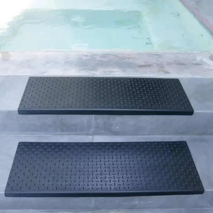 Non-Skid, Affordable, Sturdy and Eco-Friendly Step Mats black in color placed on staircase near swimming pool