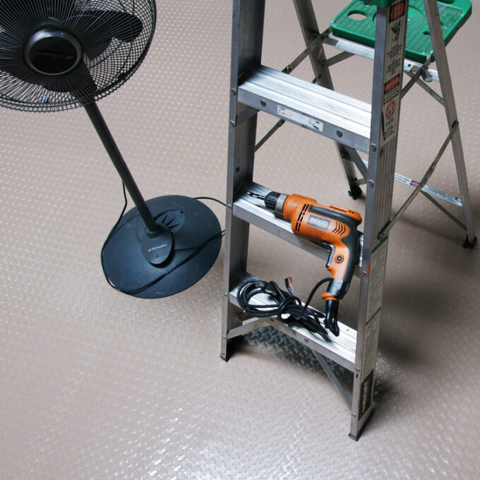 Durable PVC Flooring with a Unique Metallic Color beige placed on floor a metal ladder & floor fan placed on it