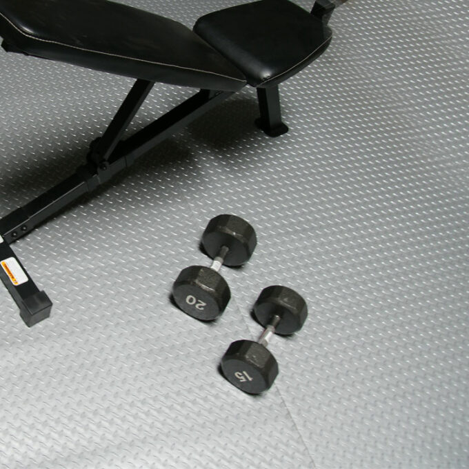 Durable PVC Flooring with a Unique Metallic Color silver placed on gym floor some weights and gym equipment placed on it
