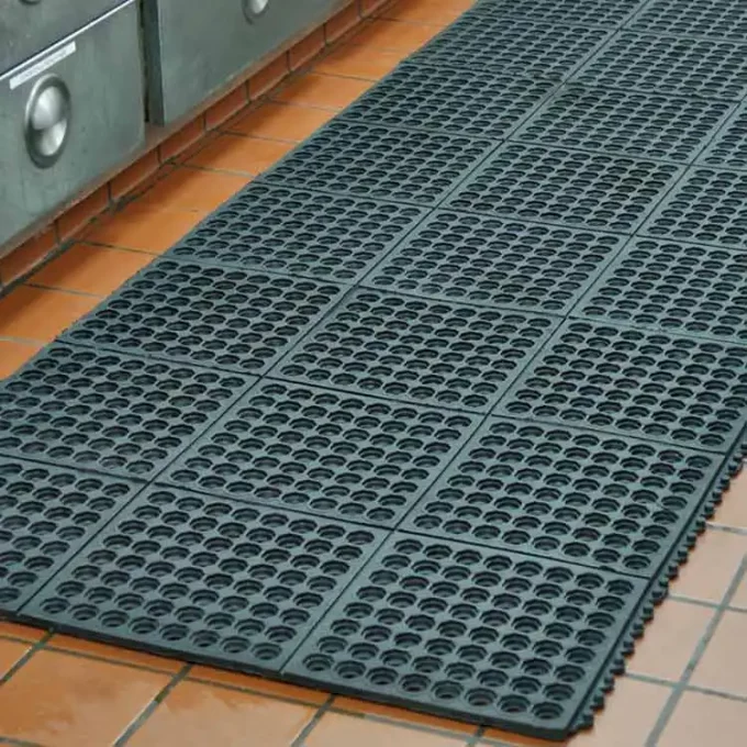 Black color door mat placed on kitchen floor