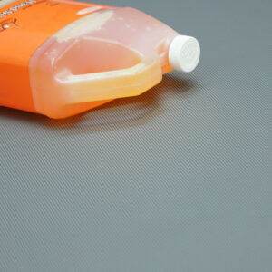 Orange bottle on top of a fine rib gray mat