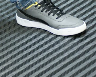 Left grey shoe on top of a black rubber mat