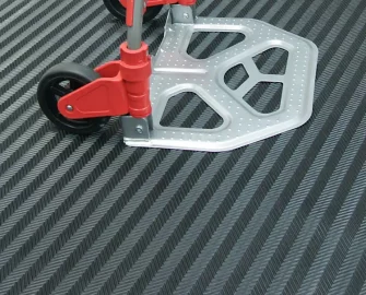 A dolly with red handles on top of a rubber mat