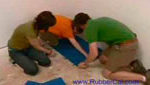 Two people installing rubber floorings