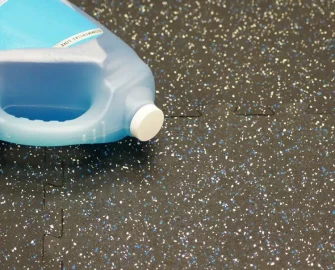 Speckled tile with blue bottle on the left side on the ground