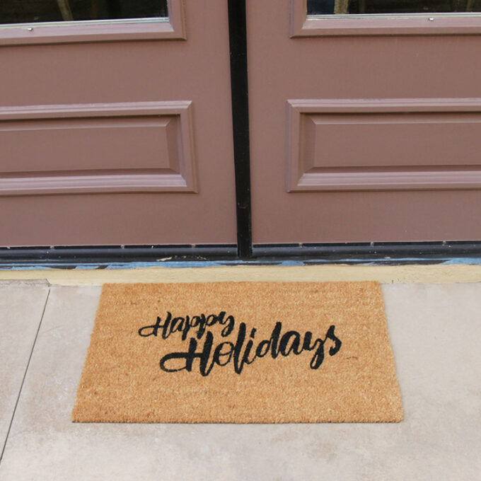 A christmas doormat with happy holidays to all message