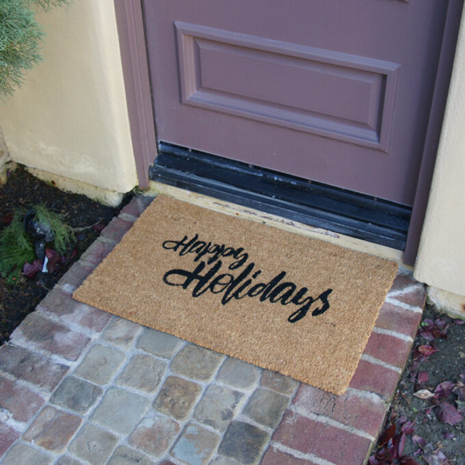A christmas doormat with happy holidays to all message