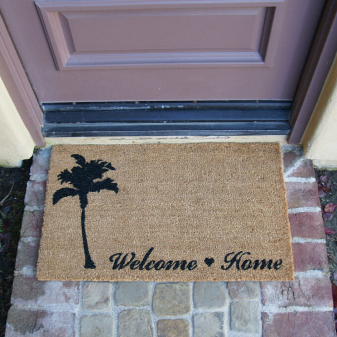 Beach themed welcome home mat with picture of tree