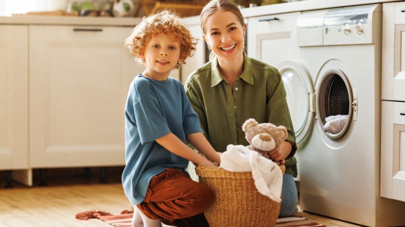 Cheerful Son Helping Mother Doing Laundry
